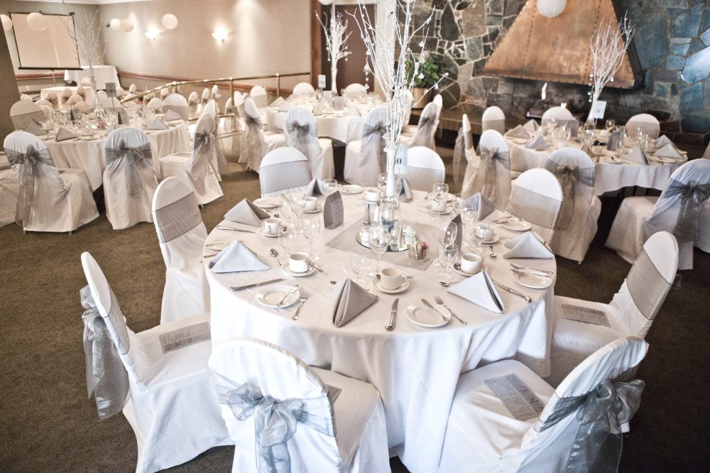 Round tables dressed in white and silver for a wedding reception