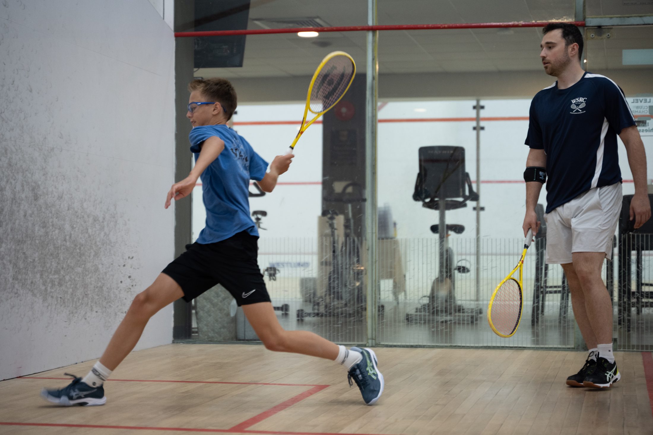A junior player working with Thomas King on court