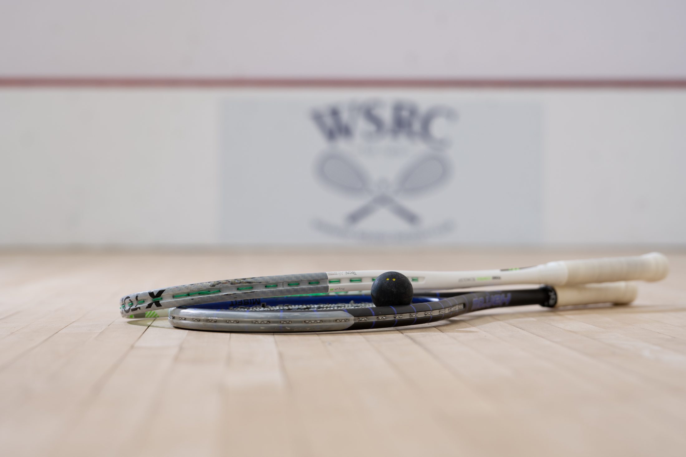 Racquets and a ball in front of the WSRC crest
