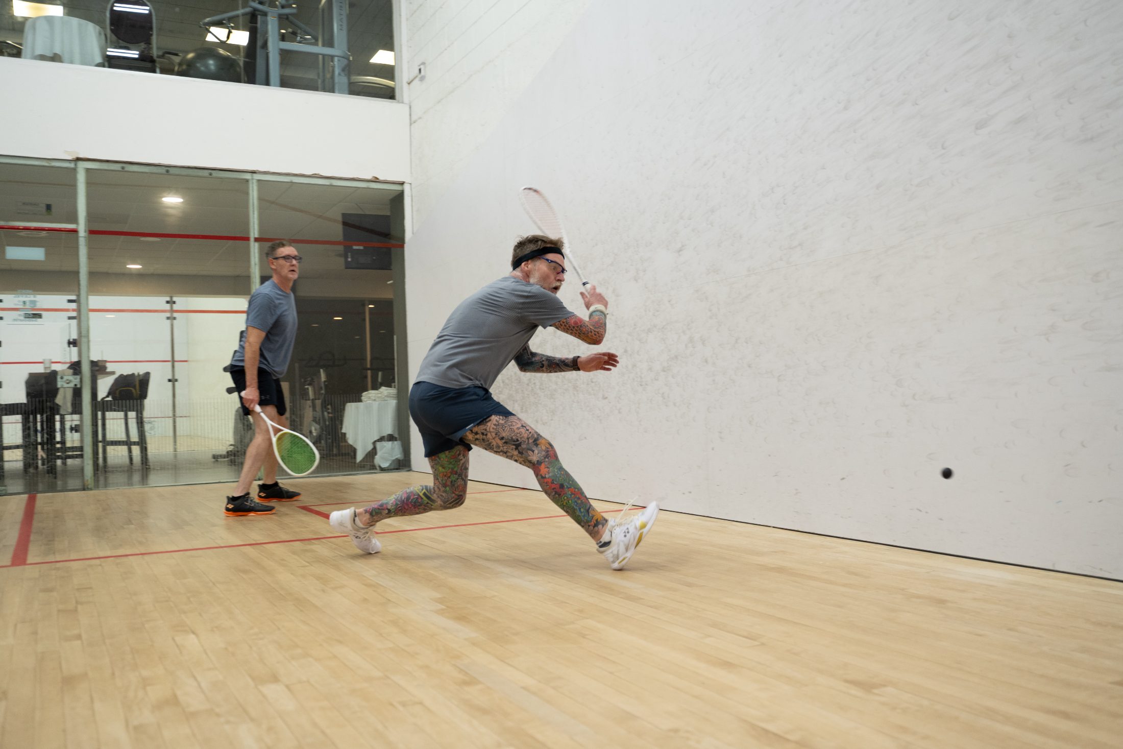 Members mid-rally on a squash court at the Winnipeg Squash Racquet Club